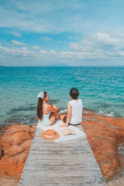 Foto ein paar genießt einen strandurlaub in einem tropischen resort mit einem wunderschön angelegten küstenpool bei sonnenuntergang als flitterwochenziel in thailand