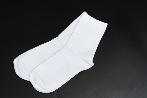 Ein Paar kurze weiße Socken auf schwarzem Hintergrund. Accessoires für Männer und Frauen. Bekleidungsgeschäft.