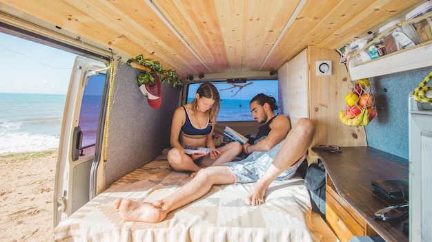 Ein Paar liest Bücher im Bett in einem Wohnwagen