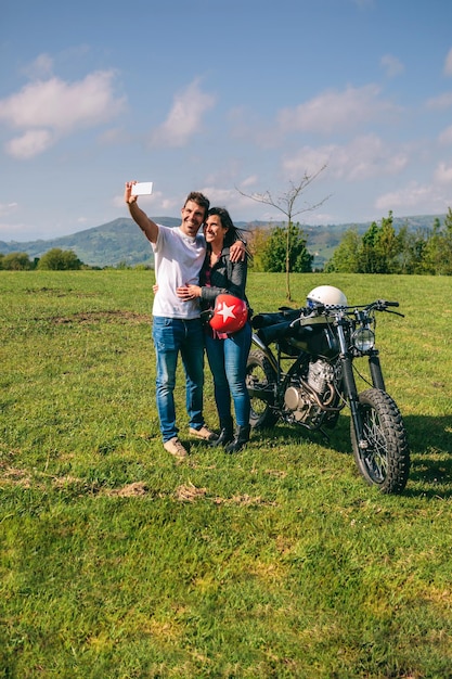 Ein Paar macht ein Selfie mit einem Motorrad