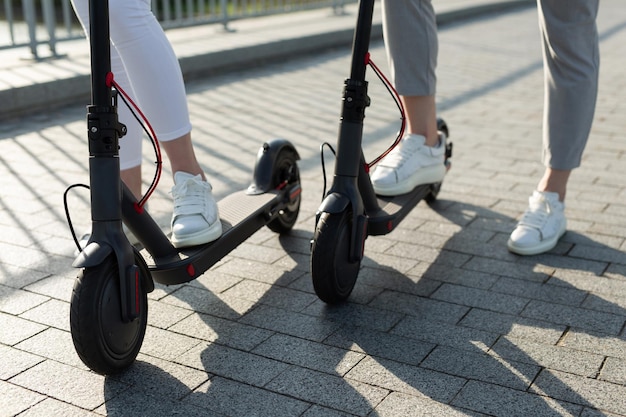 Ein paar Männer und Frauen gehen im Park spazieren und schieben Elektroroller