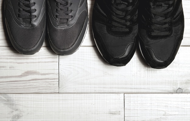 Ein Paar männliche und weibliche Schuhe auf einem Holzboden