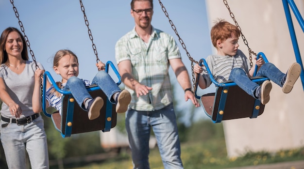 Ein Paar mit zwei Kindern, die auf dem Spielplatz spielen, ist das Konzept der Familienunterhaltung