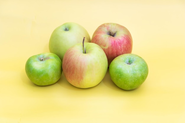Ein paar Äpfel auf gelbem Hintergrund Vorteile des Apfelkonzepts