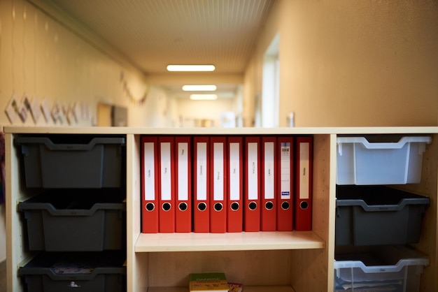 Ein paar rote Ordner in einem Regal in einem Schulbüro