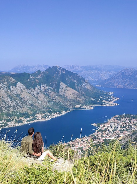 Ein Paar sitzt und betrachtet die Bucht von Kotor von oben in Kotor Montenegro