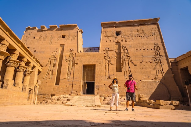 Ein paar touristen im tempel von philae, einem griechisch-römischen bau, der vom nil aus gesehen wurde, ein tempel, der der isis-göttin der liebe assuan ägypter gewidmet ist