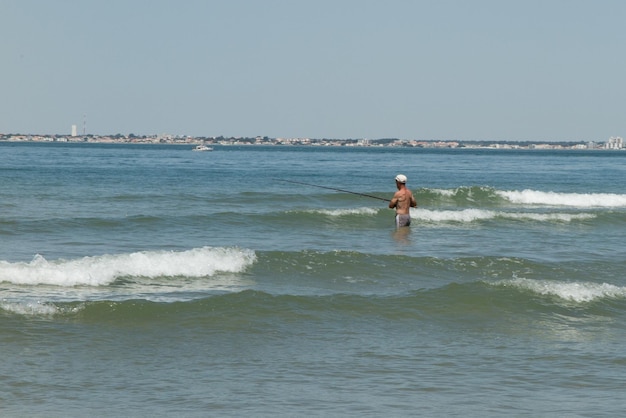 Ein pensionierter Fischer im Wasser am Strand