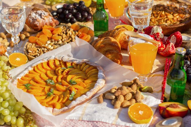 Foto ein picknick im park mit schönen gläsern, obst und gebäck.