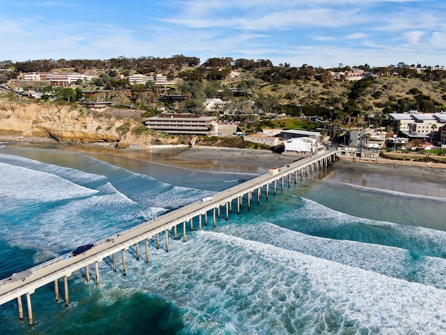 Ein Pier am Strand mit einer Stadt im Hintergrund