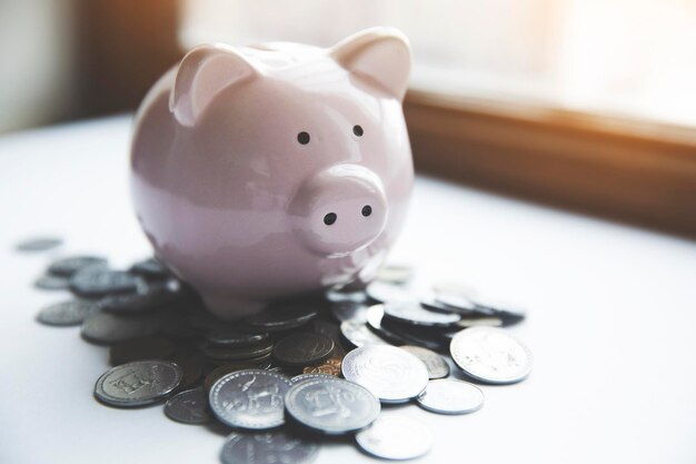 Foto ein piggybank sitzt auf einem tisch vor einem fenster