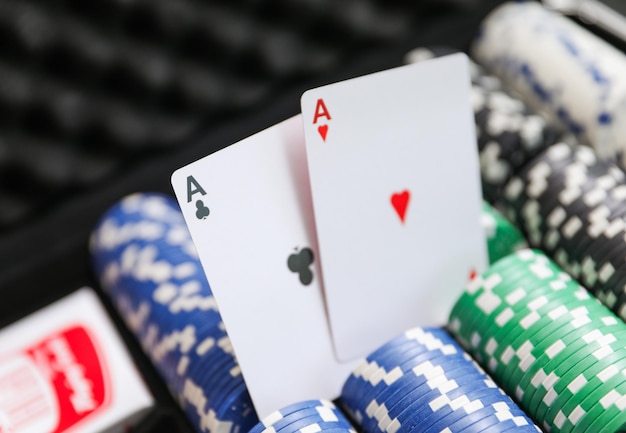 ein Pokertisch mit Pokerchips und ein Pokerspieler im Hintergrund.