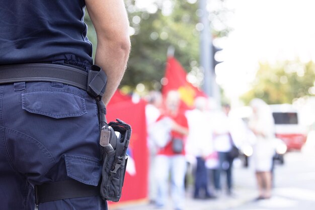 Foto ein polizist im dienst während eines straßenprotests verschwommen den demonstranten im hintergrund