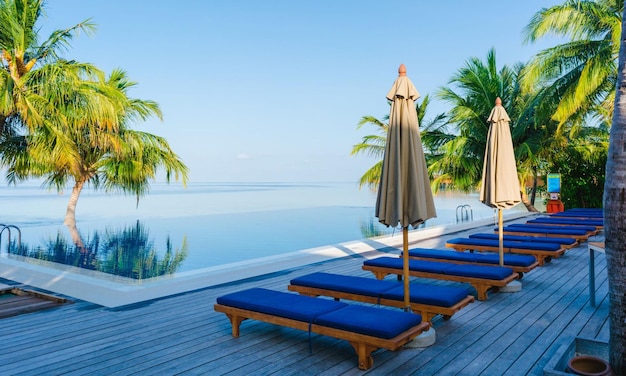 Foto ein pool mit palmen und einem blauen regenschirm