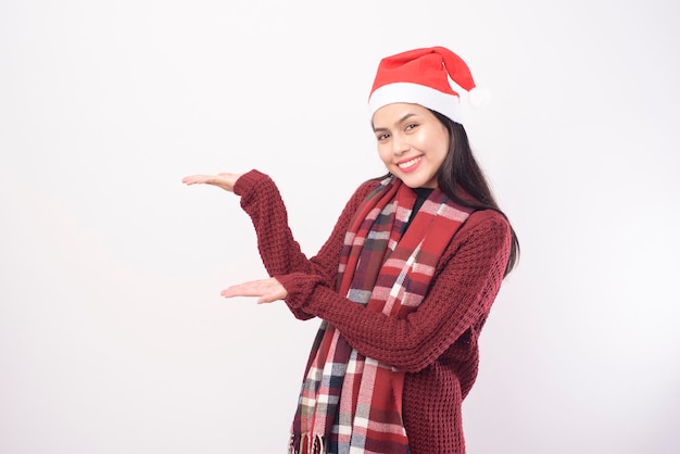 Ein Porträt der jungen lächelnden Frau, die roten Weihnachtsmann-Hut trägt, lokalisierte weißes Hintergrundstudio.