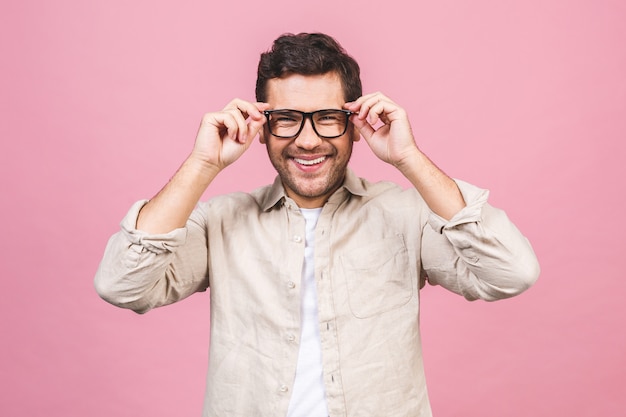 Ein Porträt des jungen lächelnden gutaussehenden Geschäftsmannes im Freizeithemd, das seine Brille berührt.