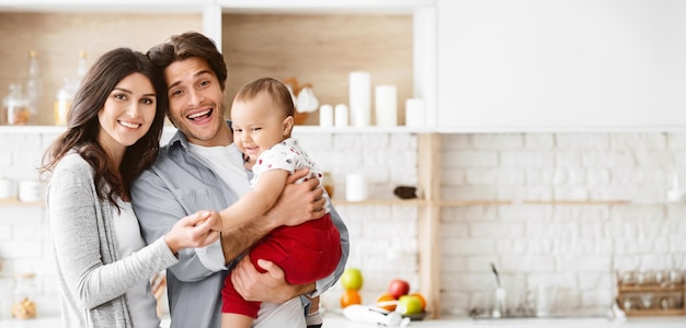 Ein Porträt einer glücklichen Familie in ihrer modernen Küche die Eltern ein Mann und eine Frau lächeln