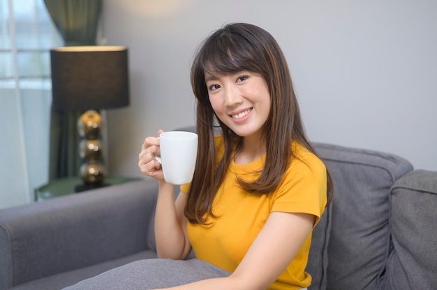 Ein Porträt einer jungen schönen Frau, die eine Tasse Kaffee trinkt