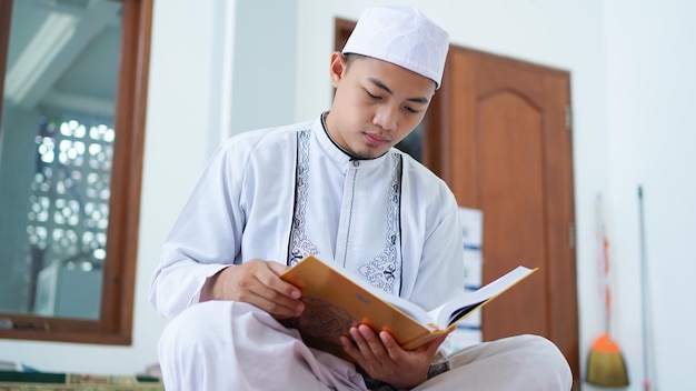 Ein Porträt eines asiatischen muslimischen Mannes, der Koran hält