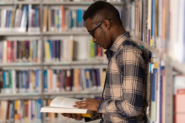 Ein Porträt eines kaukasischen College-Student-Mannes in der Bibliothek. Geringe Schärfentiefe