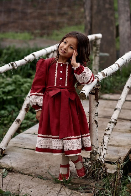 Ein Porträt süßer Kinder in schönem Kleid auf einem Bauernhof