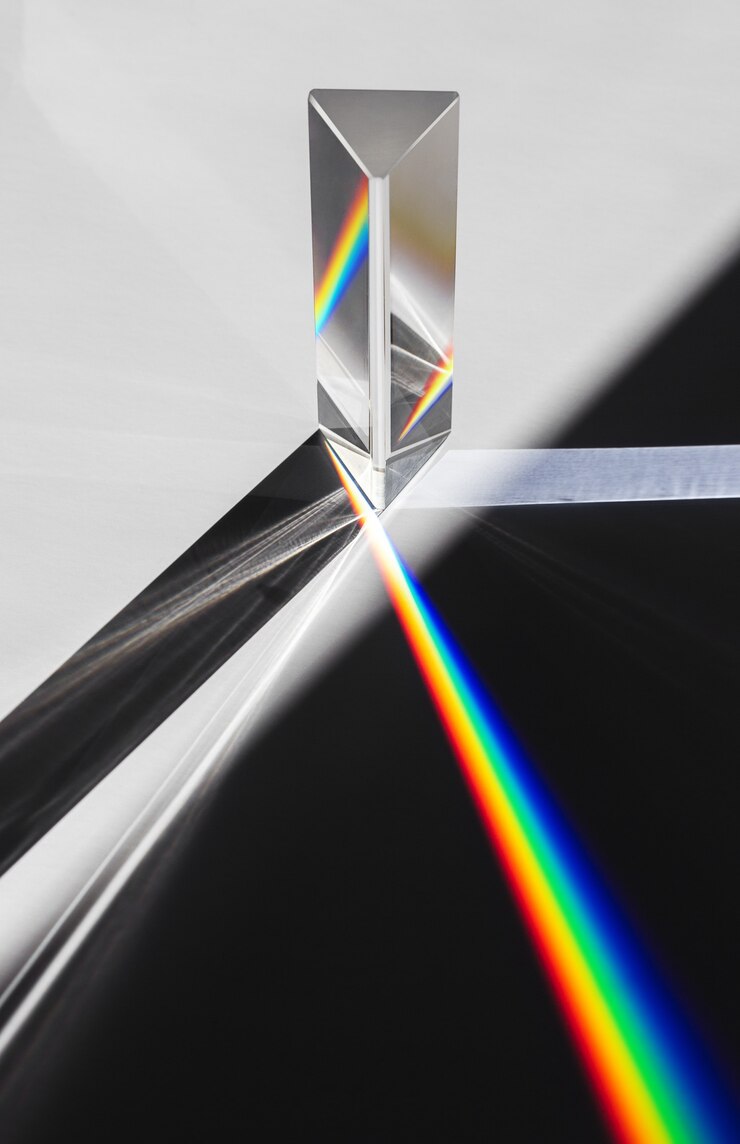 Ein Prisma, das das Sonnenlicht zerstreut, das sich in ein Spektrum auf weißem Hintergrund aufspaltet.