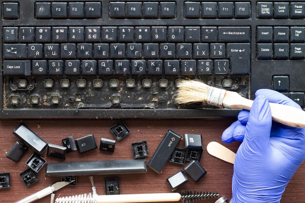 Foto ein professioneller computerelektroniker reinigt eine schmutzige computertastatur mit der entfernten taste