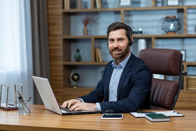 Ein professioneller erwachsener Mann in einem Geschäftsanzug arbeitet in seinem gut organisierten und stilvollen Heimbüro