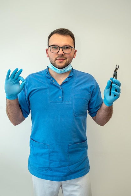 Ein professioneller junger Zahnarzt in medizinischer Kleidung wartet auf seine Patienten