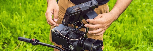 Ein professioneller Kameramann bereitet eine Kamera und ein Stativ vor, bevor er BANNER im Langformat dreht