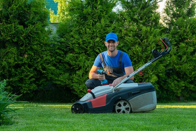 Ein professioneller Mechaniker repariert einen Rasenmäher ein Mann repariert einen Rasenmäher in seinem Garten