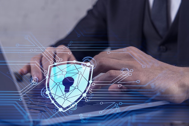 Ein Programmierer gibt einen Code auf dem Computer ein, um eine Cyber-Sicherheit vor Hackerangriffen zu schützen und vertrauliche Daten der Kunden zu speichern Vorhängeschloss-Hologramm-Symbole über den Schreibhänden Formelle Kleidung
