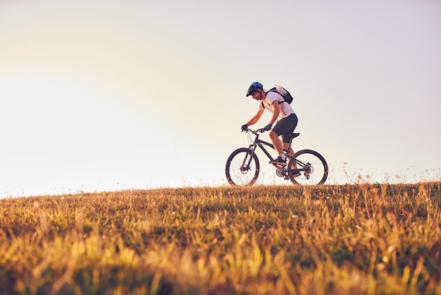 Ein Radfahrer fährt bei Sonnenuntergang Fahrrad auf Waldwegen