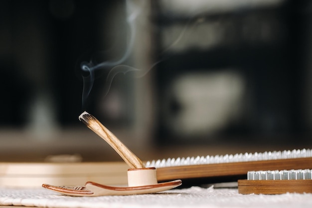 Ein rauchender Palo-Santo-Stick und Bretter mit Nägeln für Yoga-Kurse