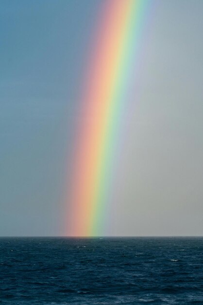 ein Regenbogen ist am Himmel über einem Boot zu sehen