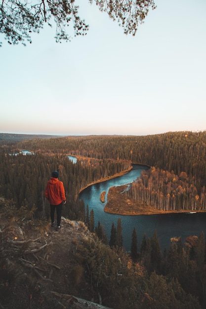 Ein Reisender schaut bei Sonnenuntergang auf die Kurve des Flusses Kitkajoki in Oulanka im Norden Finnlands