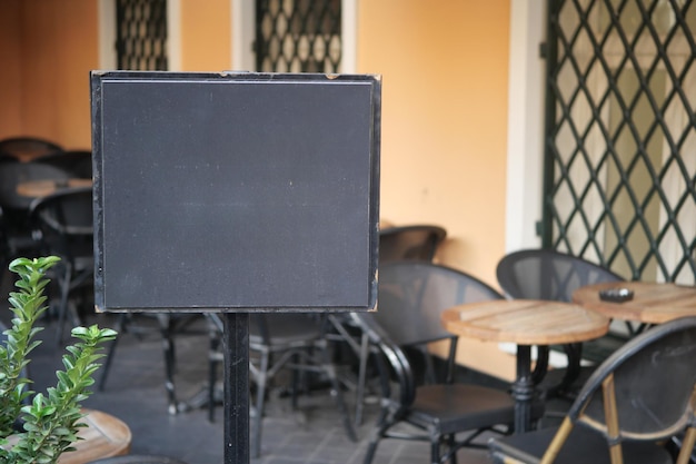 Ein Restaurant im Freien mit einer leeren Menütafel, die auf die Ankunft der Kunden wartet