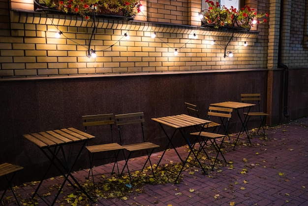 Ein Restaurant mit einer Backsteinmauer und einer Reihe von Tischen und Stühlen, an deren Decke Lichter hängen