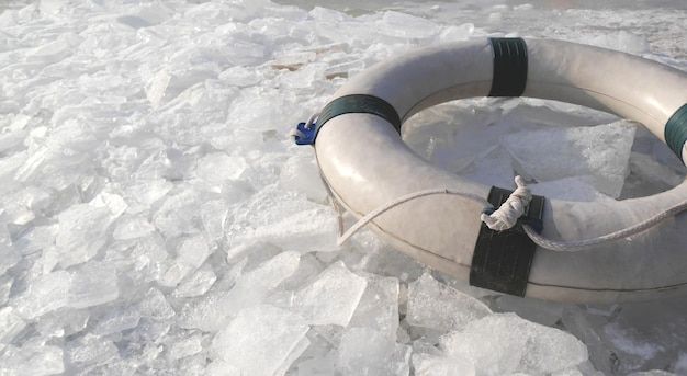 Ein Rettungsring auf der Eisschwimmstelle am winterlichen Strand und Eissplittern