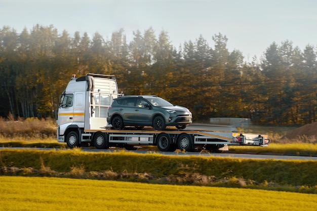 Ein Rollback-Schleppwagen transportiert ein defektes Auto auf der öffentlichen Straße.