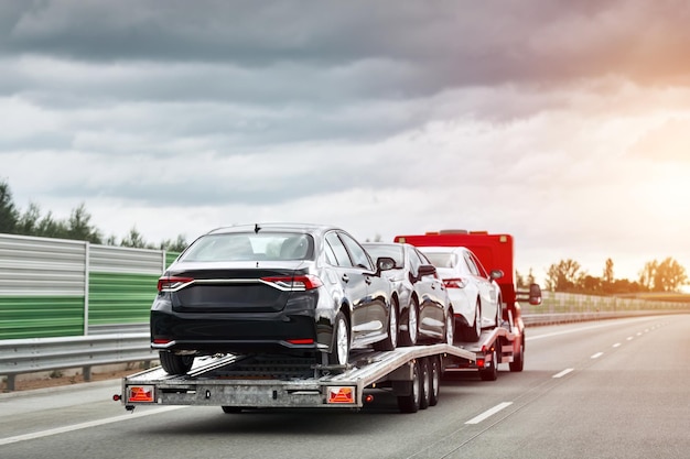 Ein Rollback-Schleppwagen transportiert ein kaputtes Auto auf der öffentlichen Straße Autofehler während der Fahrt Straßenhilfe in Aktion