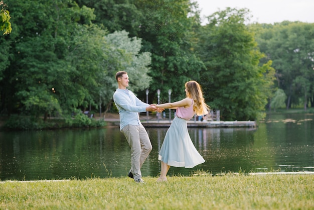 Ein romantisches Paar in der Liebe, die Hände hält und auf das Ufer des Sees spinnt