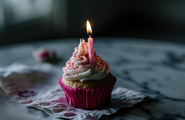 ein rosa Cupcake mit einer Geburtstagskerze in Rosa und Weiß