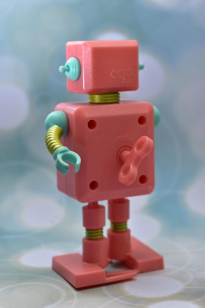 Ein rosa Roboter mit einem rot-blauen Kästchen auf der Vorderseite.