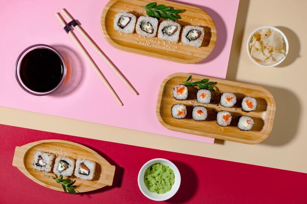 Ein rosa Tisch mit Sushi und einer Schüssel grünem Tee