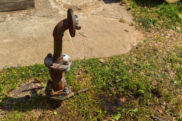 Foto ein rostiges, korrosives altes industrielles wasserversorgungsrohr aus eisen für die wasserversorgung mit einem sich bewegenden flansch