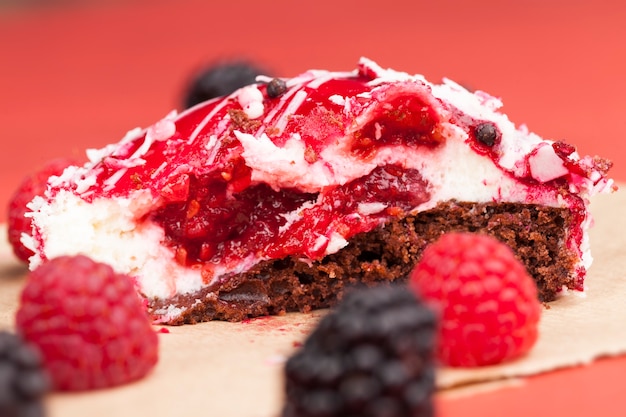 Ein roter Kuchen mit cremeweißer Füllung, rote Marmelade mit Himbeeren und Brombeeren