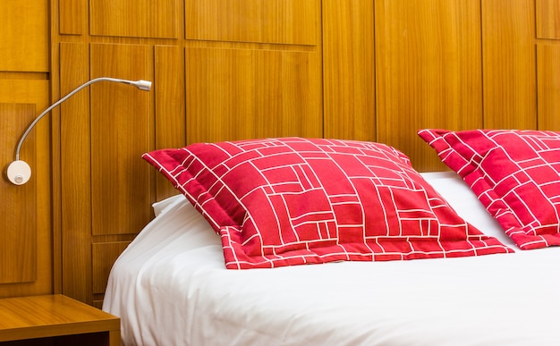Ein rotes Designkissen in einem modernen Schlafzimmer