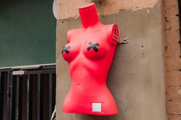 Ein rotes Mannequin des Frauentorsos mit schwarzen, kreuzförmigen, selbstklebenden Brustwarzenabdeckungen auf den Brüsten Sale Store Classic Business Imitation Sculpture Object Commerce Naked Clothing Studio Manikin