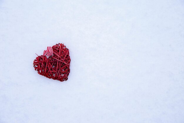 Ein rotes Weidenherz im Schnee mit Platz für Text